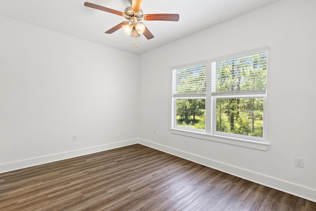 unfurnished room with baseboards, dark wood-type flooring, and ceiling fan