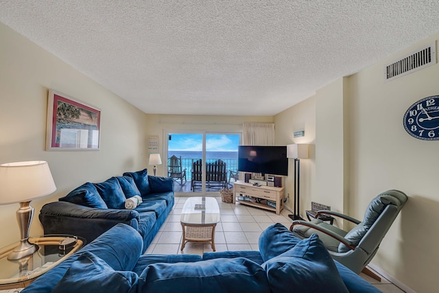 5801 Thomas Dr Unit 620, Panama City Beach, FL 32408 - living room with light tile patterned flooring, a textured ceiling, visible vents, and baseboards