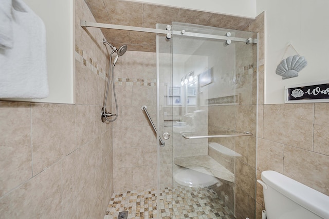 5801 Thomas Dr Unit 620, Panama City Beach, FL 32408 - bathroom featuring tile walls, toilet, and a shower stall