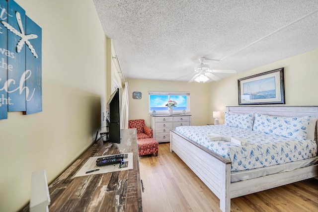 5801 Thomas Dr Unit 620, Panama City Beach, FL 32408 - bedroom with a ceiling fan, light wood-type flooring, and a textured ceiling