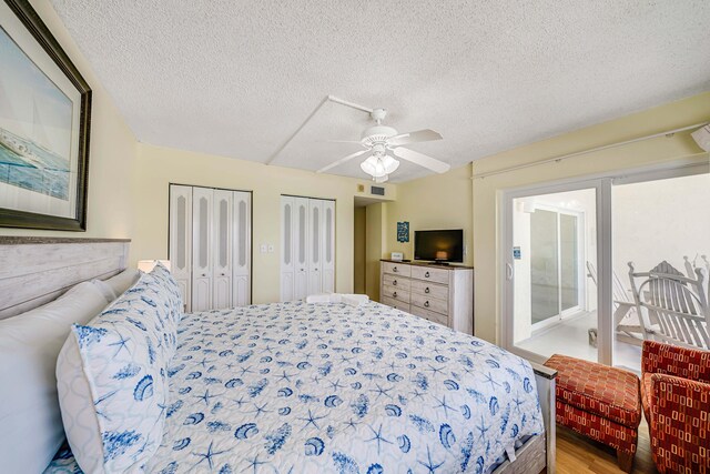 5801 Thomas Dr Unit 620, Panama City Beach, FL 32408 - bedroom featuring ceiling fan, a textured ceiling, multiple closets, wood finished floors, and visible vents