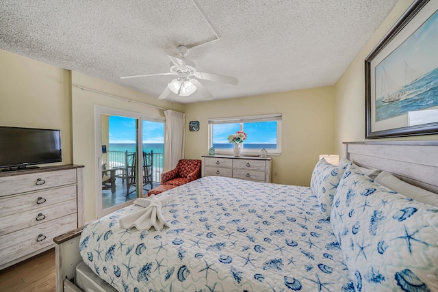 5801 Thomas Dr Unit 620, Panama City Beach, FL 32408 - bedroom featuring a ceiling fan, a textured ceiling, access to exterior, and wood finished floors