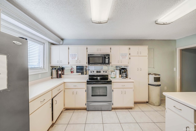 5801 Thomas Dr Unit 620, Panama City Beach, FL 32408 - kitchen with white cabinets, light countertops, a textured ceiling, stainless steel appliances, and light tile patterned floors