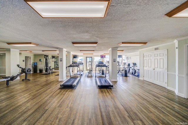 5801 Thomas Dr Unit 620, Panama City Beach, FL 32408 - workout area with decorative columns, a textured ceiling, visible vents, wood finished floors, and baseboards