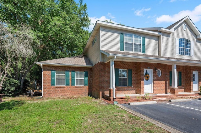 1901 Cottage Grove Ln Unit 1, Niceville, FL 32578 - view of front of property with brick siding, uncovered parking, and a front lawn