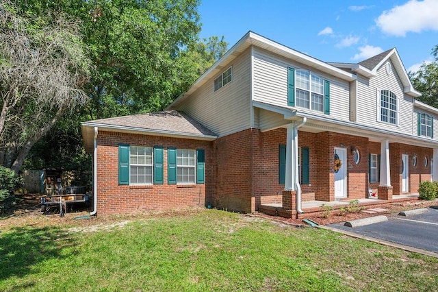 1901 Cottage Grove Ln Unit 1, Niceville, FL 32578 - view of front of house with brick siding, a front yard, covered porch, and roof with shingles