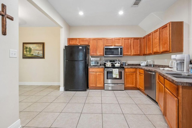 1901 Cottage Grove Ln Unit 1, Niceville, FL 32578 - kitchen featuring stainless steel appliances, dark countertops, light tile patterned flooring, brown cabinetry, and recessed lighting