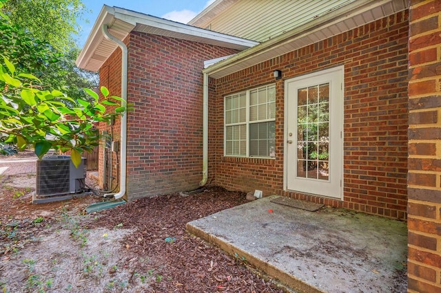 1901 Cottage Grove Ln Unit 1, Niceville, FL 32578 - view of exterior entry featuring cooling unit, brick siding, and a patio