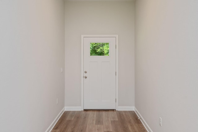 doorway with light wood-style flooring and baseboards