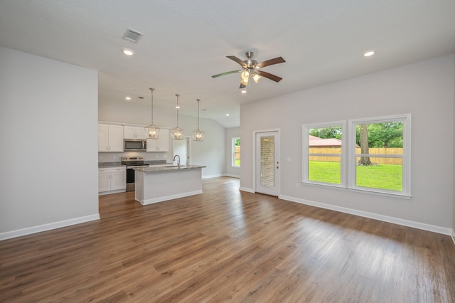 unfurnished living room with a sink, baseboards, visible vents, and wood finished floors