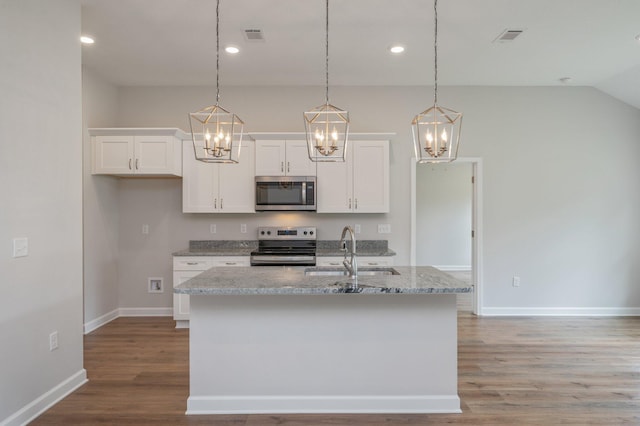 kitchen with a sink, an inviting chandelier, white cabinets, and appliances with stainless steel finishes