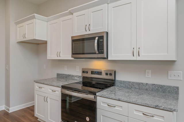 kitchen featuring baseboards, dark wood-style flooring, light stone counters, white cabinetry, and stainless steel appliances