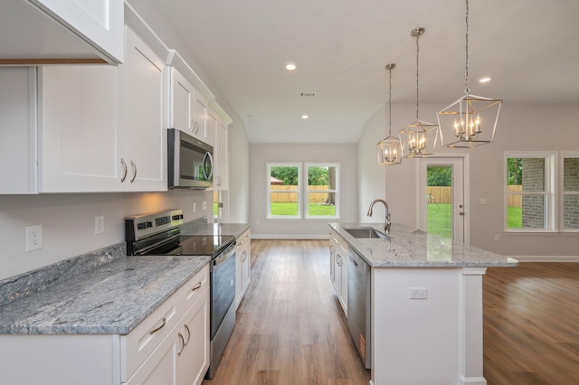 kitchen with a sink, white cabinetry, light wood-style floors, and appliances with stainless steel finishes