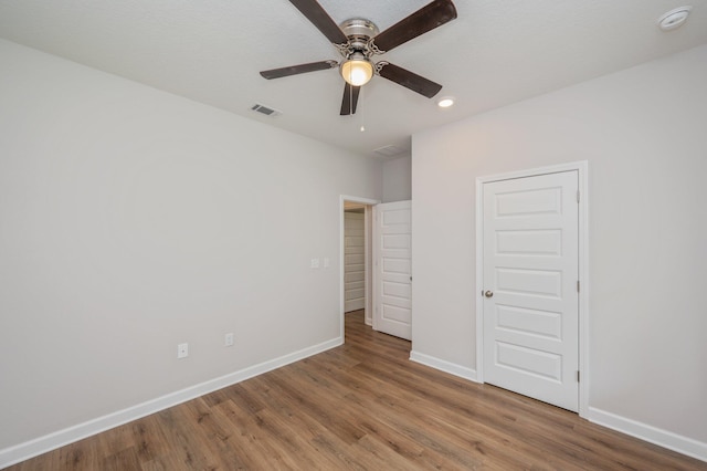 unfurnished bedroom with wood finished floors, a ceiling fan, visible vents, baseboards, and recessed lighting
