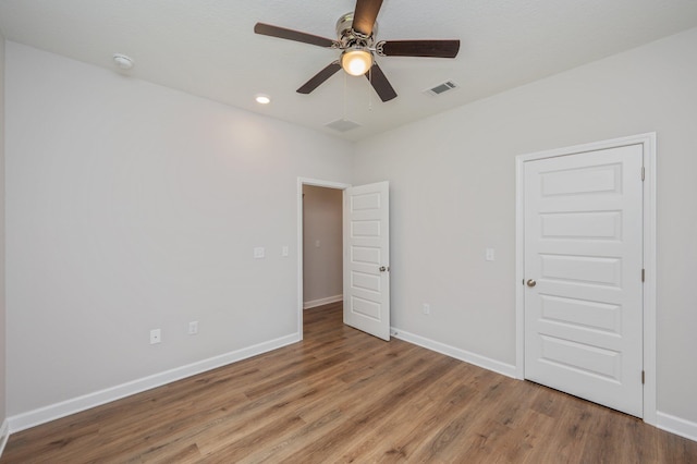 unfurnished bedroom with visible vents, wood finished floors, and baseboards