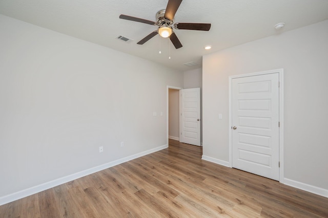 unfurnished bedroom with visible vents, light wood-style flooring, baseboards, and ceiling fan