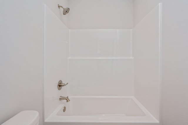 bathroom with bathing tub / shower combination and toilet