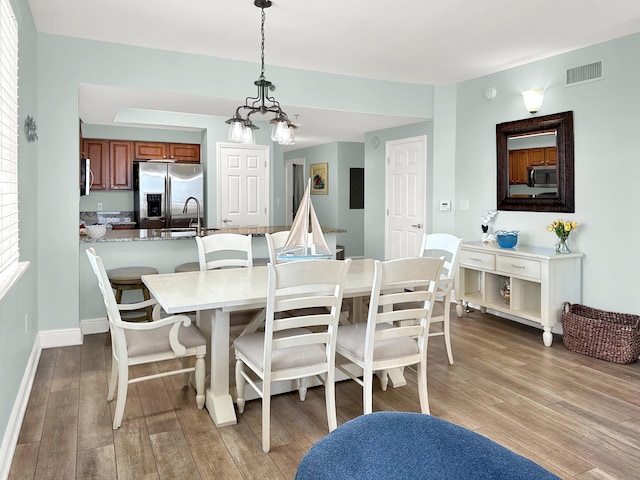 112 Seascape Dr Unit 310, Miramar Beach, FL 32550 - dining area with light wood-type flooring, a chandelier, and baseboards