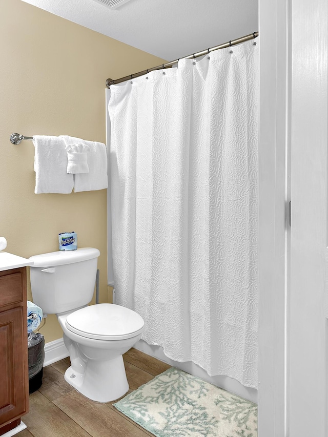 112 Seascape Dr Unit 310, Miramar Beach, FL 32550 - bathroom featuring toilet, wood finished floors, a shower with curtain, and baseboards
