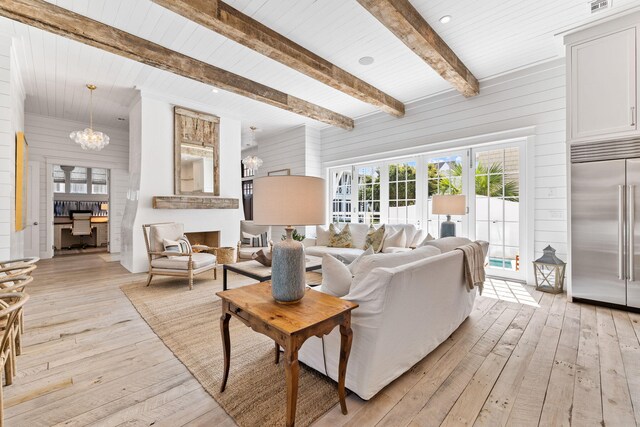 28 Rainer Ln, Inlet Beach, FL 32461 - living room featuring wood walls, beam ceiling, an inviting chandelier, and light wood-type flooring