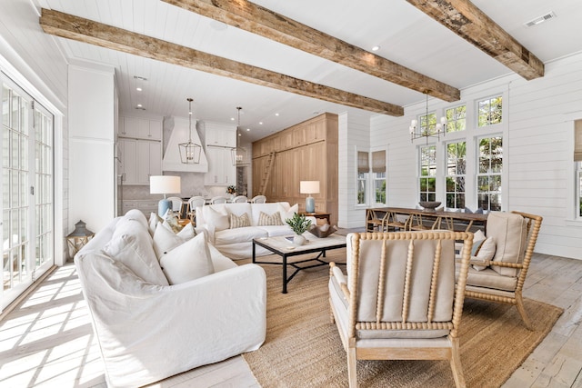 28 Rainer Ln, Inlet Beach, FL 32461 - living room with light wood finished floors, wood walls, visible vents, beamed ceiling, and a chandelier
