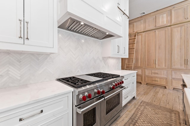 28 Rainer Ln, Inlet Beach, FL 32461 - kitchen with light stone countertops, double oven range, custom exhaust hood, white cabinets, and tasteful backsplash