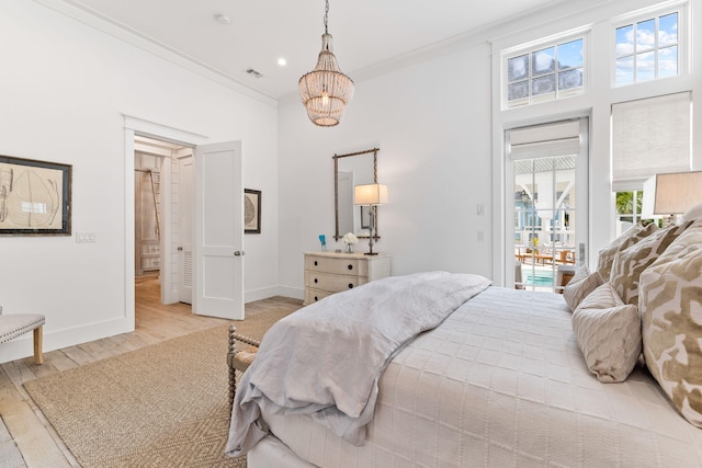 28 Rainer Ln, Inlet Beach, FL 32461 - bedroom with baseboards, light wood finished floors, an inviting chandelier, crown molding, and access to exterior
