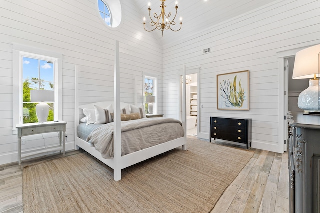 28 Rainer Ln, Inlet Beach, FL 32461 - bedroom with a notable chandelier, wood-type flooring, multiple windows, wood walls, and a high ceiling