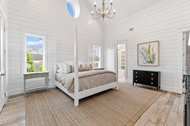 28 Rainer Ln, Inlet Beach, FL 32461 - bedroom with an inviting chandelier, light wood-style floors, wooden walls, and a high ceiling