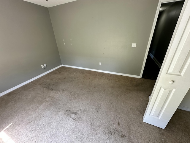carpeted spare room featuring baseboards