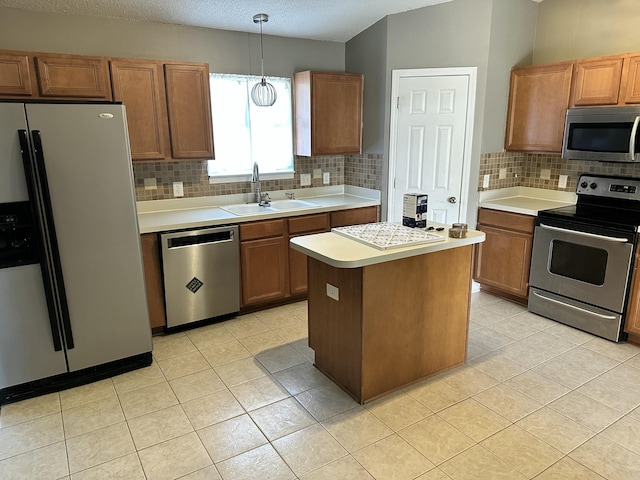 kitchen with light countertops, a sink, appliances with stainless steel finishes, and tasteful backsplash