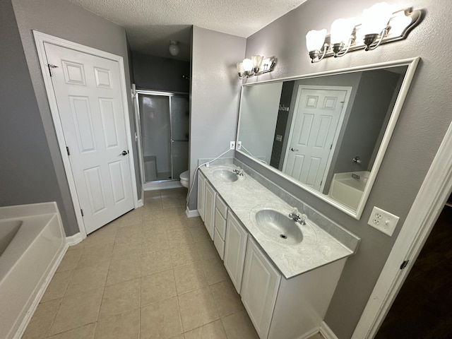 bathroom featuring a sink, tile patterned flooring, a shower stall, and a textured ceiling