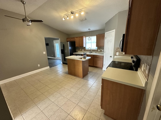 kitchen featuring visible vents, a center island, light tile patterned floors, appliances with stainless steel finishes, and backsplash