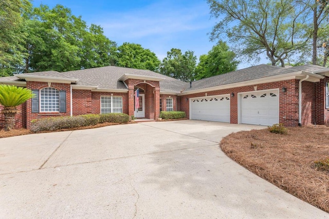 ranch-style home with driveway, an attached garage, brick siding, and a shingled roof