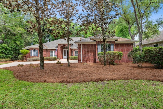 ranch-style home featuring brick siding and a front yard