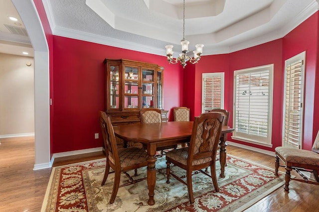 dining area with a raised ceiling, a chandelier, wood finished floors, baseboards, and recessed lighting