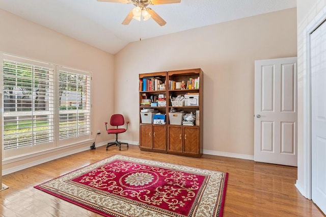 sitting room featuring plenty of natural light, a ceiling fan, wood finished floors, baseboards, and lofted ceiling