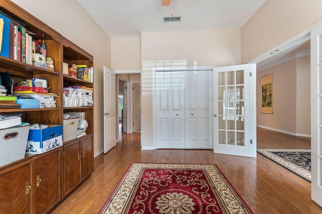 foyer entrance featuring light wood-type flooring, baseboards, and french doors