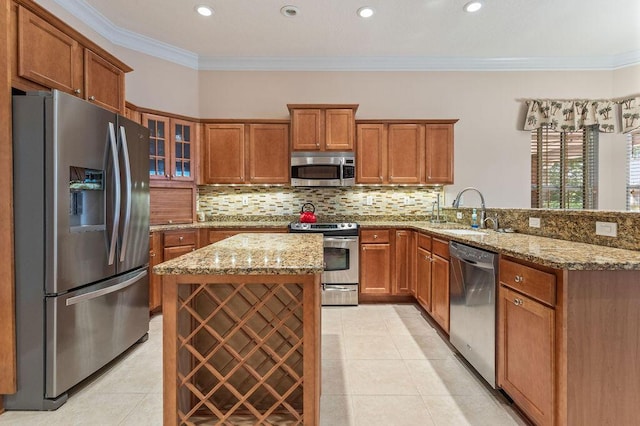 kitchen with stainless steel appliances, a sink, light tile patterned floors, brown cabinets, and crown molding