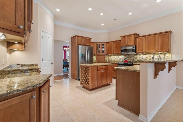 kitchen featuring stainless steel appliances, brown cabinetry, stone countertops, tasteful backsplash, and ornamental molding