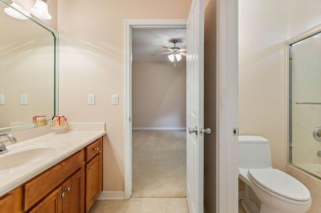 bathroom with ceiling fan, vanity, toilet, tile patterned floors, and baseboards