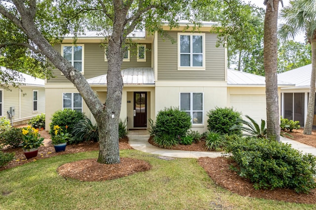 2021 Pine Island Cir, Miramar Beach, FL 32550 - view of front of home featuring a garage, a front lawn, stucco siding, a standing seam roof, and metal roof