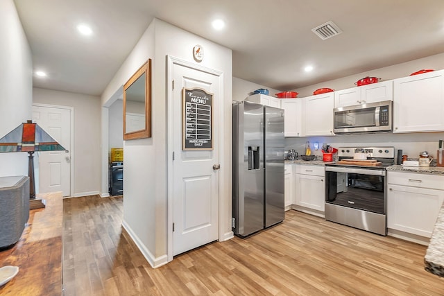 kitchen with light stone counters, stainless steel appliances, light wood finished floors, and white cabinetry