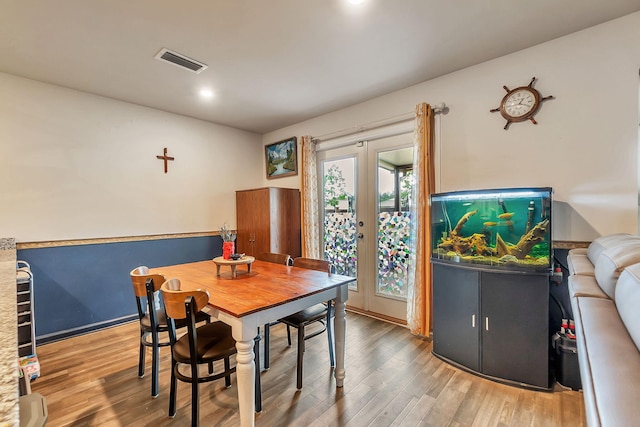 dining room featuring baseboards, visible vents, french doors, and wood finished floors