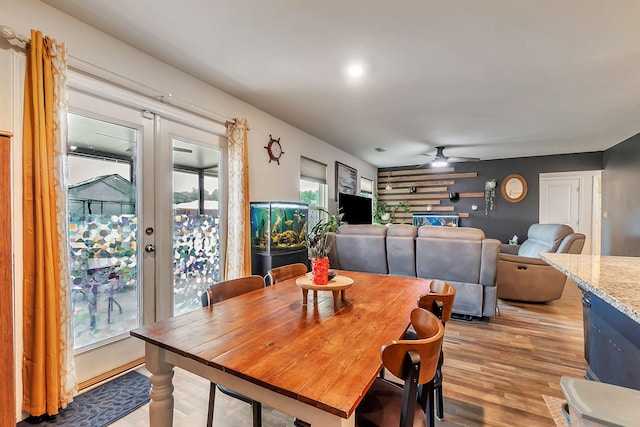 dining area featuring light wood-style floors, a ceiling fan, and french doors