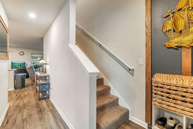staircase featuring baseboards and wood finished floors
