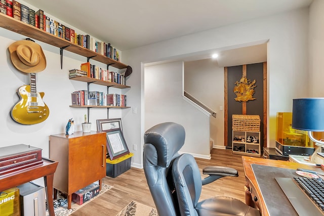 office area with baseboards and light wood-style flooring