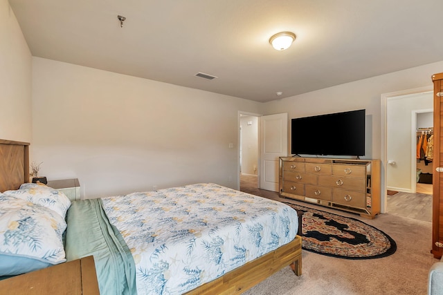 carpeted bedroom with visible vents and a spacious closet