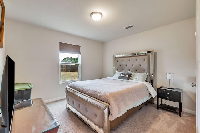 bedroom featuring baseboards, visible vents, and light carpet