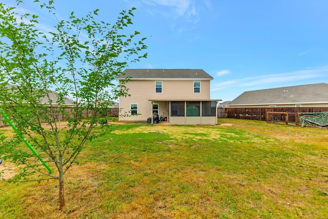 back of house featuring a sunroom, a fenced backyard, and a lawn